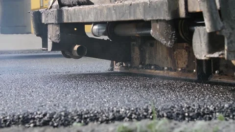 Blacktop spread over roadway, screeded by road paver and compressed by roller Stock Footage 158040923