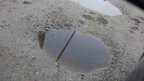Blade of a windmill to generate wind energy reflected in a puddle Stock Footage 236511177