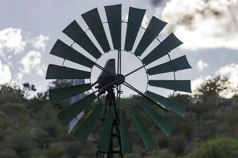 Blades of  wind engine lifting water from well for watering wild animals. Stock Photos