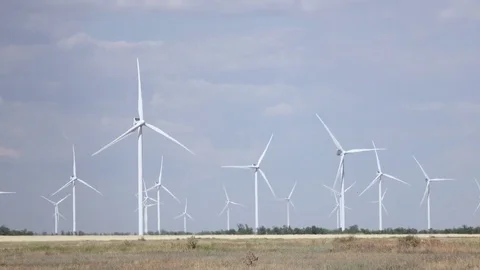 Blades of wind turbines rotate from the wind tree leaves and grass sway Stock Footage 79085763