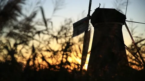 The blades of windmill rotating, with sunset golden light Stockbeeldmateriaal 295361475