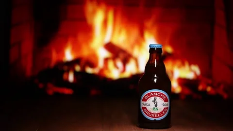 Blanche de Bruxelles Beer bottle against the background of the fireplace. Stock Footage 163352667
