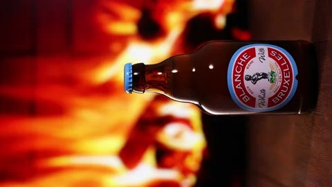 Blanche de Bruxelles Beer bottle against the background of the fireplace. Stock Footage 163434535