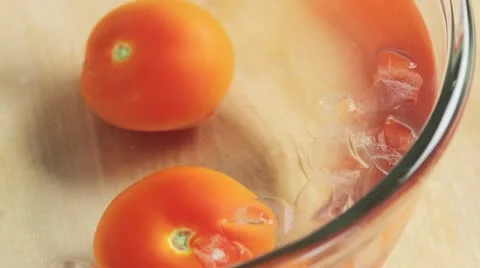 Blanched tomatoes being removed from the iced water Stock Footage 24673207