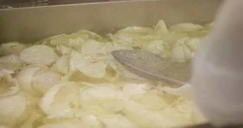 Blanched white cabbage leaves floating in hot water inside a stainless steel Vídeo Stock 339968540