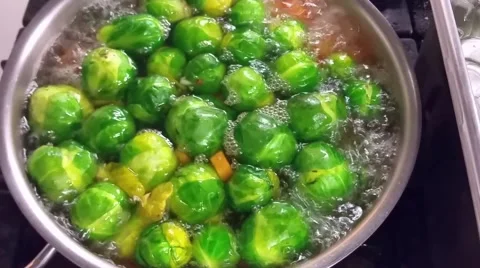 Blanching green brussels sprouts and carrots, at a restaurant kitchen Stock Footage