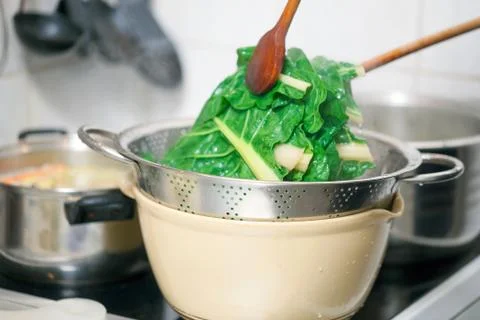 Blanching hot chard using kitchenware Stock Photos