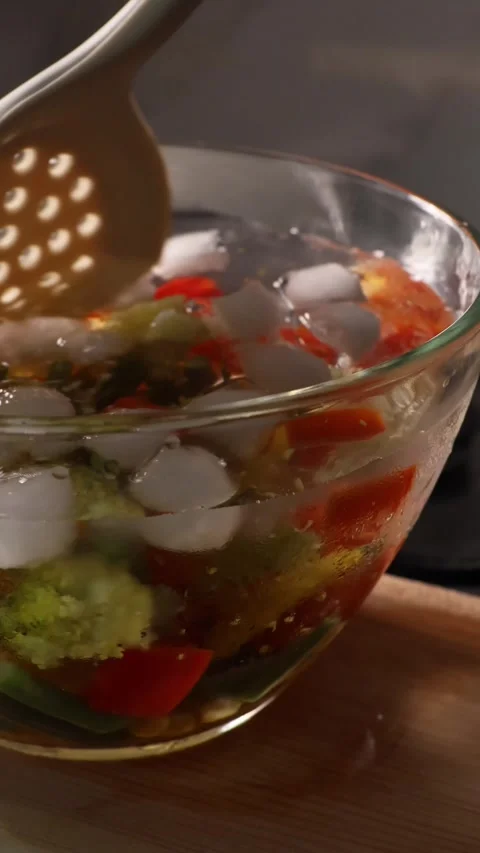 Blanching vegetables in ice bath after boiling in a cozy home kitchen 動画素材 345584395