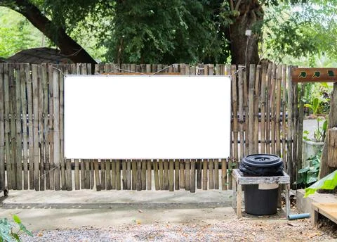 Blank billboard mockup rectangle on the bamboo wall with a trash can nearby.. Stock Photos