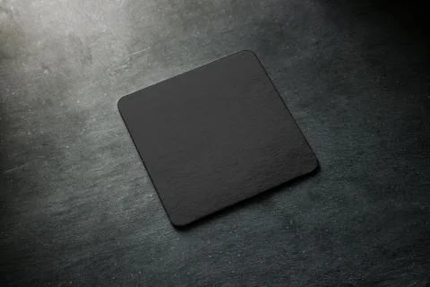 Blank black beer coaster mockup lying on grey desk. Stock Illustration