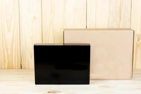 Blank black box and blank brown box on wooden table.Zoom in Stock Photos