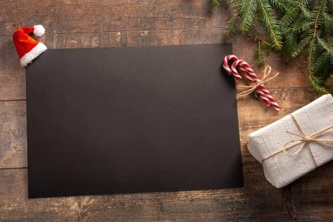 Blank black sheet of paper with composition on the dark wooden texture. Mocku Stock Photos