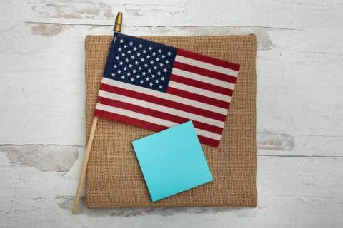 Blank blue posted note with one Amerian flag flat lay Stock Photos