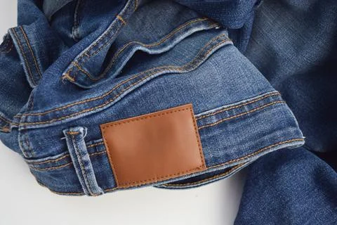 A blank brown leather label patch on the waistband of blue denim jeans, moc.. Stock Photos
