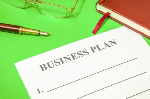 Blank of business plan and notepad on a green office desk Stock Photos