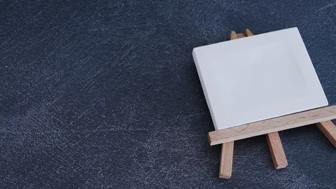 Blank canvas and group of coloured pencils thrown next to it Stock Footage 116645918