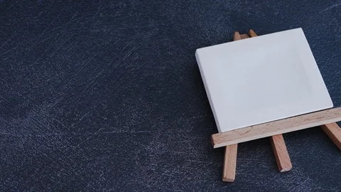 Blank canvas on dark desk and group of coloured pencils entering the scene Stock Footage 116645910