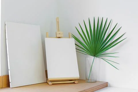 Blank canvas on the easel on the table Stock Photos