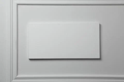 Blank canvas hanging on white wall, space for text 写真素材