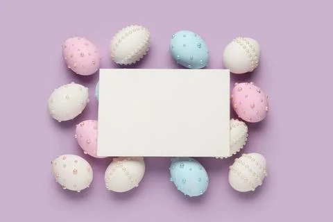 Blank card and Easter eggs decorated with pearls on purple background Stock Photos