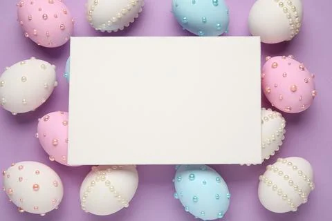 Blank card and Easter eggs decorated with pearls on purple background Stock Photos