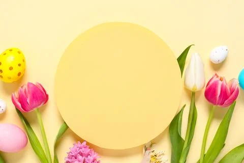 Blank card with Easter eggs and flowers on beige background Stock Photos