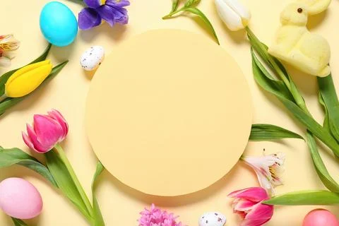 Blank card with Easter eggs, toy bunny and flowers on beige background Stock Photos