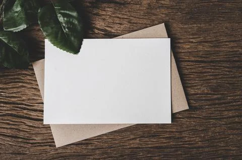 A blank card is placed on envelope and leaf with wood background Stock Photos
