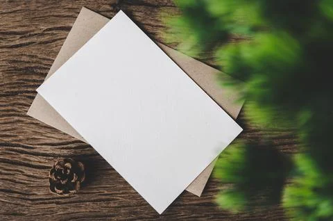 A blank card is placed on envelope and leaf with wood background Stock Photos