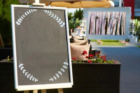 Blank chalkboard with white frame in front of wedding ceremony Stock Photos