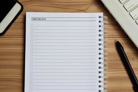Blank checklist with space for ticks on notepad with laptop, smartphone and pen. Foto stock