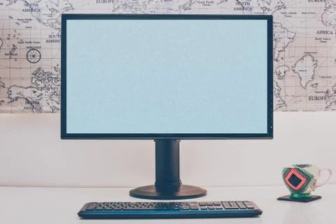 Blank computer desktop with keyboard and coffee mug on white table in sunny r Stock Photos