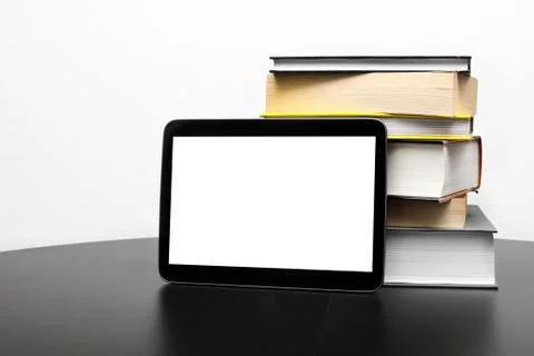 Blank digital tablet and stack of books Foto stock
