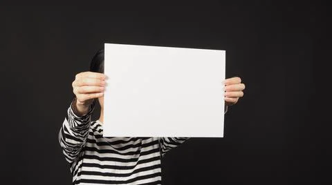 Blank empty the A4 paper in woman's hands on black background.woman wear blac Stock Photos