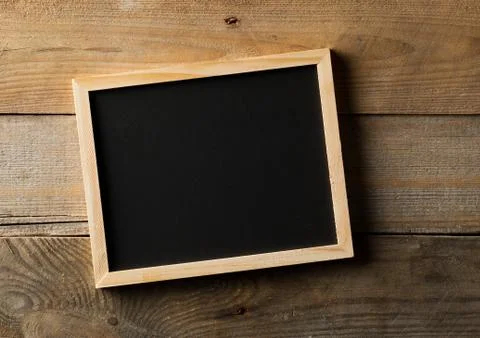 Blank, empty, black chalkboard flat lay from above on brown wooden table 스톡 사진