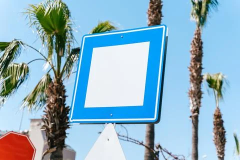 Blank empty copy space blue and white street sign with blue sky and palm trees Stock Photos