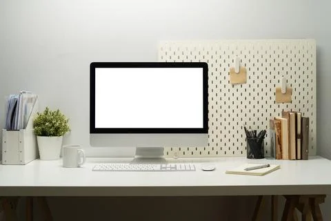Blank empty desktop computer, potted plant and books on white table. White Foto stock