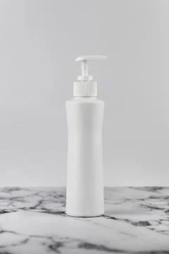 Blank empty moisturizer container on white background on marble table. Cosmet Foto stock