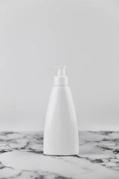 Blank empty moisturizer container on white background on marble table. Cosmet Stock Photos