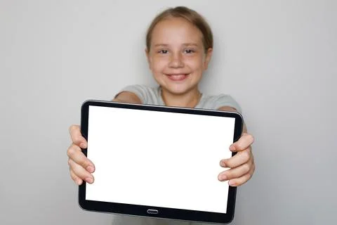 Blank empty tablet display in hands of beautiful cute child girl Stock Photos
