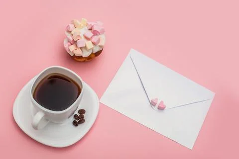 Blank envelope and White cup full of coffee with tasty cupcake with hearts from Stock Photos
