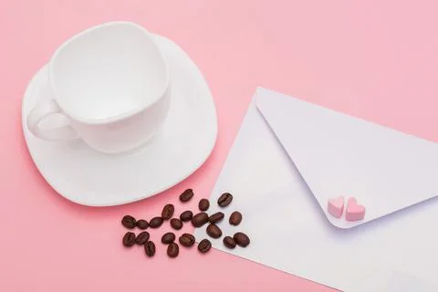 Blank envelope isolated and empty White cup with roasted coffee beans on pink Stock Photos