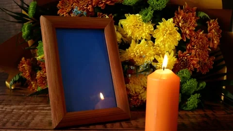 Blank frame, burning candles and flowers on table against wooden background.. Stock Footage 233829545