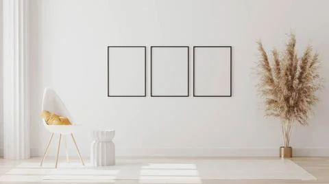 Blank frames on white wall in empty room with column and white chair with ... Stock Photos