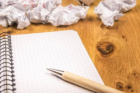 Blank graph notebook and crumpled drafts Math spiral notebook with a pen o... Stock Photos