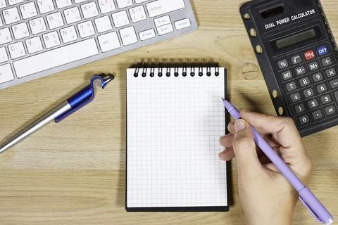 Blank Grid Notebook on Office Desk With Pen, Calculator and Keyboard for Plannin Stock Photos
