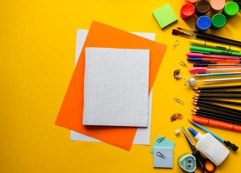Blank Grid Notebook on Orange Paper with Colorful School Supplies 스톡 사진