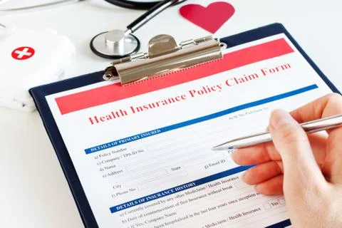 Blank health insurance policy claim form with stethoscope on clipboard. Stock Photos