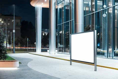 Blank horizontal banner stand next to modern building at night, 3d rendering. Ilustración de archivo