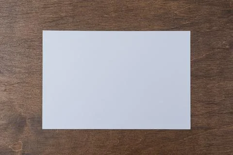 Blank horizontal postcard mockup placed on wooden table surface. Clean card.. Stock Photos